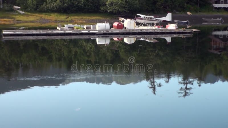 Watervliegtuighydroplane op parkerenwater op achtergrondkust in Alaska