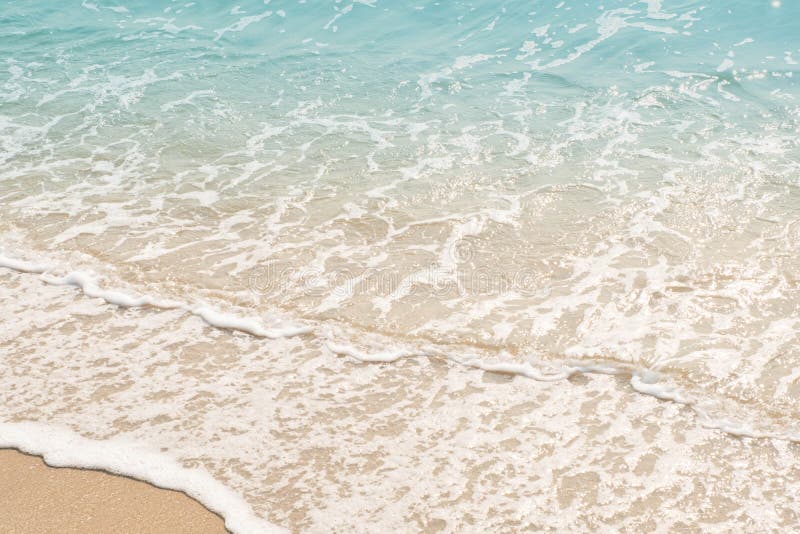 Wave of Blue Ocean on Sandy Beach. Texture Background Stock Photo