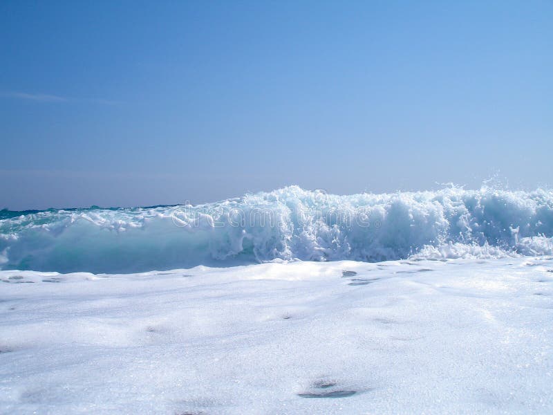 Wave breaking on blue sky stock photo