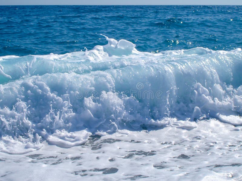 Wave breaking on blue sky royalty free stock photo