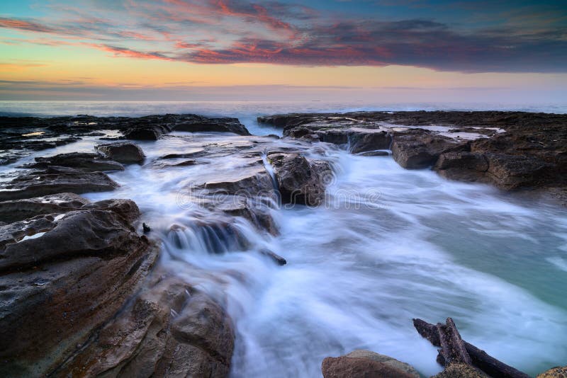 Wave circola sulle rocce stagionate e sui massi immagini stock Wave circola sulle rocce stagionate e sui massi immagini stock
