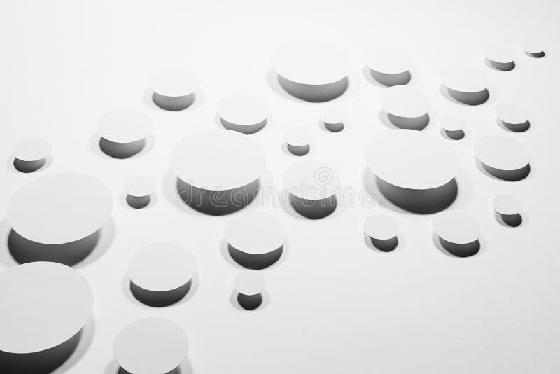 Wave of white paper ovals different size in hard light with contrast dark shadows as modern energy motion mess pattern, top view. Contemporary activity abstract background.