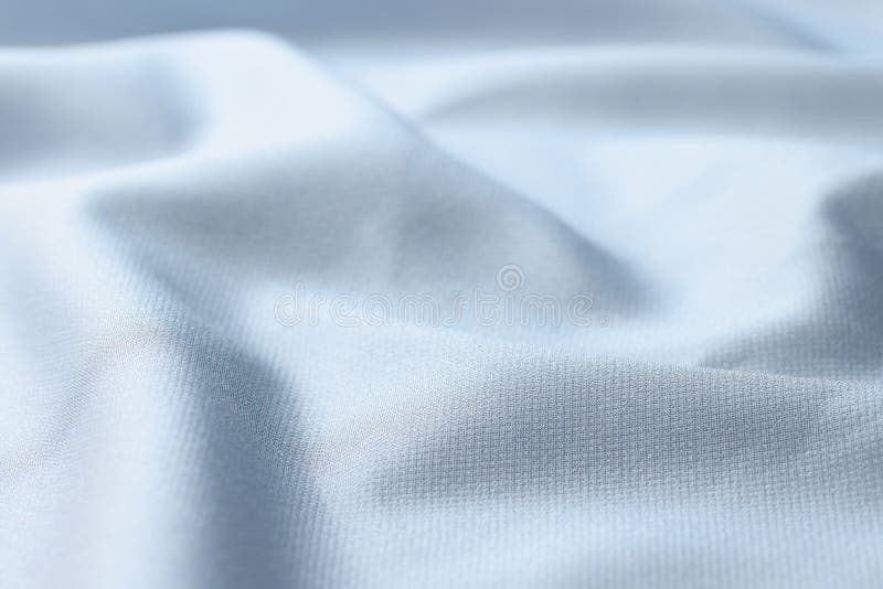 Waved light blue silk fabric background. Close up of satin textile. stock image