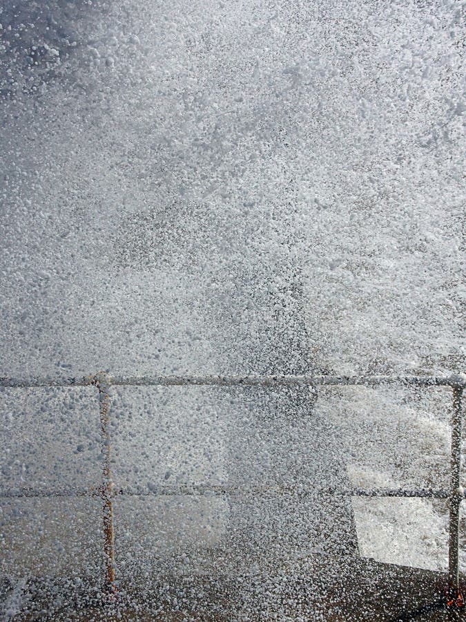 Waves breaking over the sea wall. Large Waves breaking over the sea wall. Droplets of seawater glinting in the sun. This is at Hornsea, East Yorkshire, UK stock images Waves breaking over the sea wall. Large Waves breaking over the sea wall. Droplets of seawater glinting in the sun. This is at Hornsea, East Yorkshire, UK stock images
