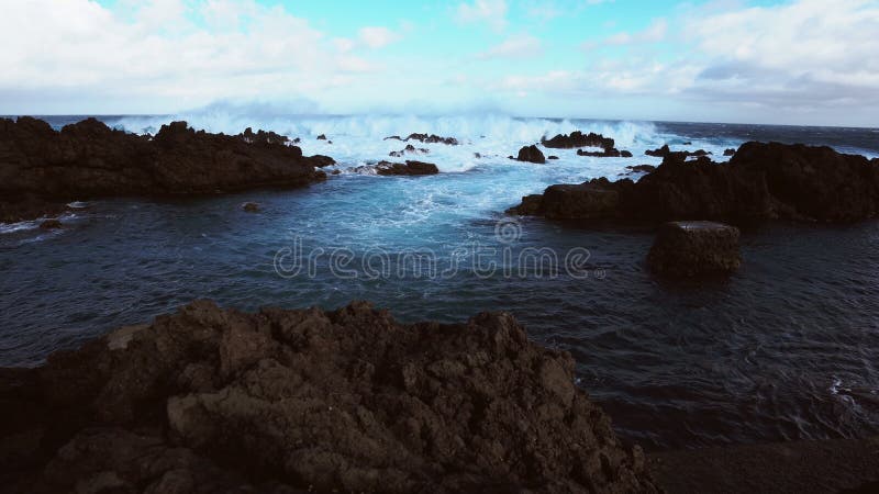 Waves breaking over volcanic rocks in biscoitos