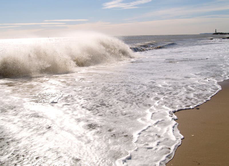 Waves crashing on sandy beach stock image