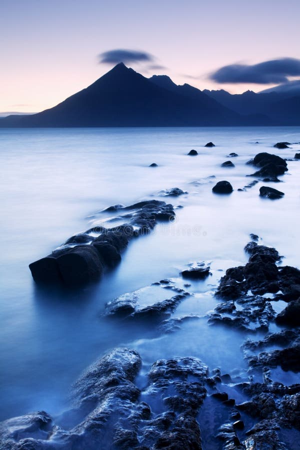 Waves crashing on shoreline with moody dramatic sky at Elgol on the Isle of Skye, Scotland, UK. morning scene.