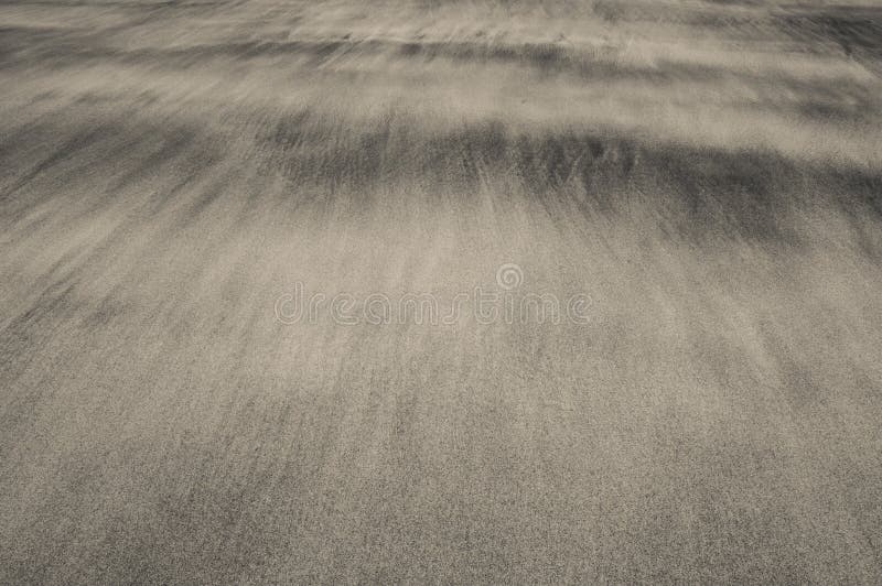 Waves of sand on a beach creating soft and delicate textures stock photo