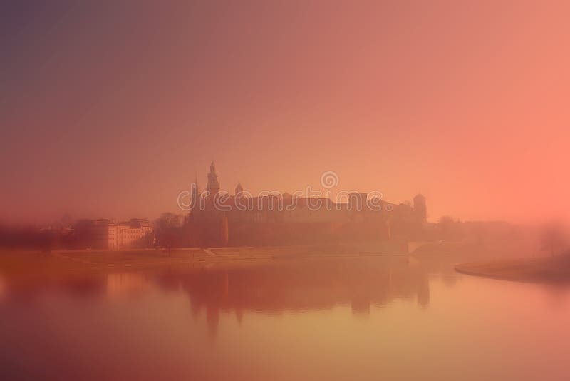 Královský Hrad Wawel zahalené v ranní mlha odrážející v Visly v Krakově v Polsku.