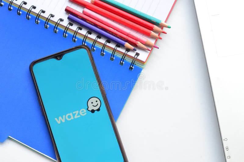 Waze apps on smartphone, with laptop book and pencil royalty free stock images