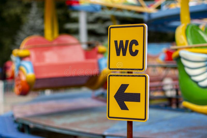 WC sign on a yellow plate with arrow pointer. Sign pointer where the toilet is located royalty free stock image WC sign on a yellow plate with arrow pointer. Sign pointer where the toilet is located royalty free stock image