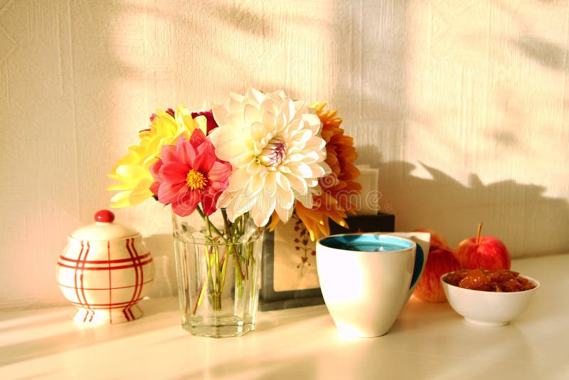 Wciąż życie z szklaną wazą z kolorowymi kwiatami peonie, filiżanka herbata, jabłczany dżem, jabłka i cukierniczka na białym stole zdjęcie stock Wciąż życie z szklaną wazą z kolorowymi kwiatami peonie, filiżanka herbata, jabłczany dżem, jabłka i cukierniczka na białym stole zdjęcie stock