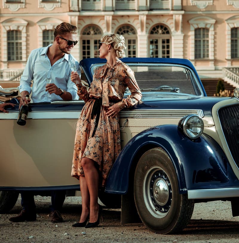 Wealthy couple near classic convertible against royal palace stock photography Wealthy couple near classic convertible against royal palace stock photography