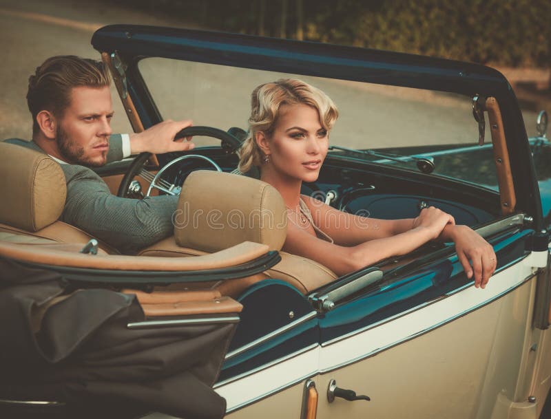 Wealthy young couple in a classic convertible royalty free stock photo Wealthy young couple in a classic convertible royalty free stock photo