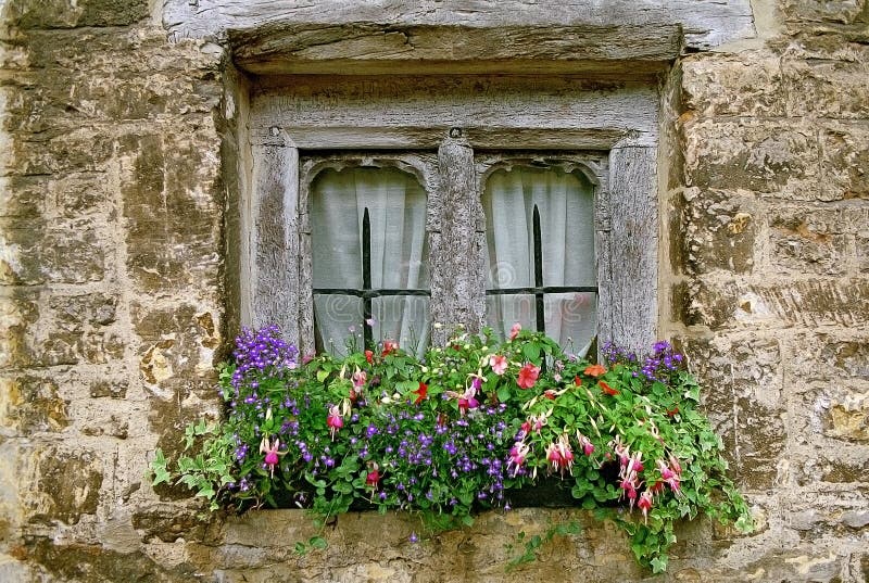 Weather-beaten wooden window with flower decoration