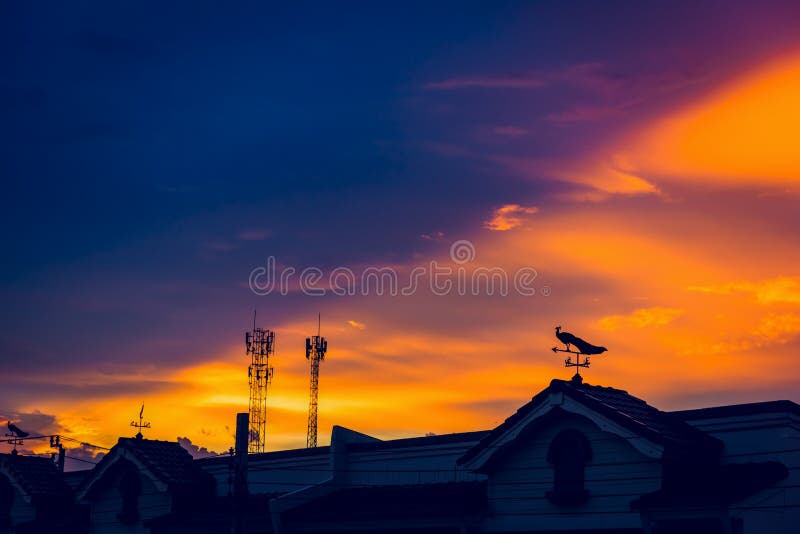 Weather Vane at Sunrise with Bright Colors in Clouds Stock Photo
