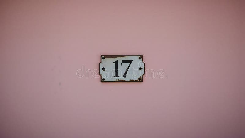 Weathered House Number \'17\' Sign on Pastel Pink Wall vector illustration