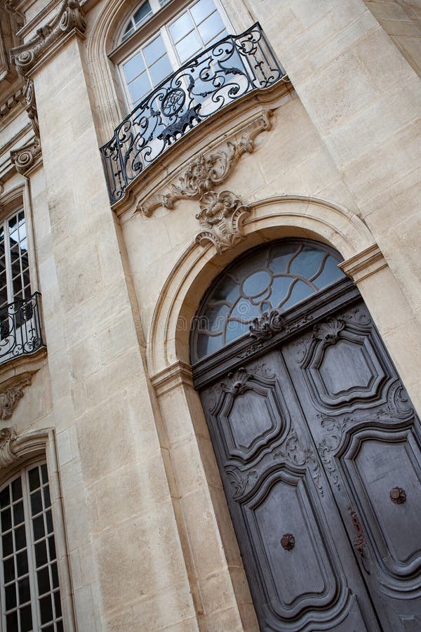 Weathered wooden door and wrought iron balcony. Facade of an old French mansion in Aix en Provence city