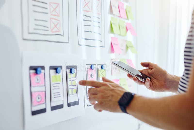 Web developer with mobile phone planning website ux app development stock photos