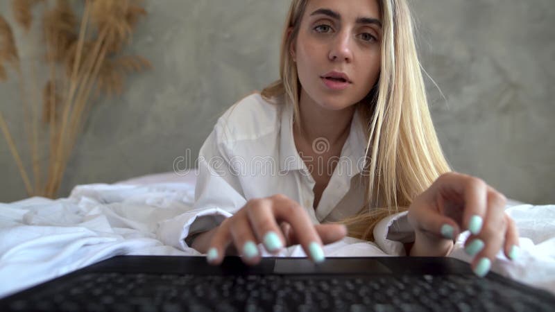 Webcam View Of A Young Beautiful Woman Lying On The Bed And Typing On