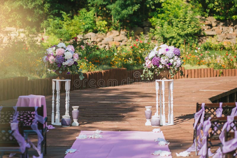 Wedding arch in a summer garden on a terrace of vintage white pedestals with purple bouquets of flowers hydrangea royalty free stock image Wedding arch in a summer garden on a terrace of vintage white pedestals with purple bouquets of flowers hydrangea royalty free stock image