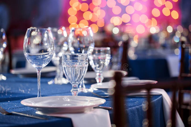 Wedding. Banquet. The chairs and round table for guests, served with cutlery and crockery and covered with a blue. Wedding. Banquet. The chairs and table for royalty free stock photo Wedding. Banquet. The chairs and round table for guests, served with cutlery and crockery and covered with a blue. Wedding. Banquet. The chairs and table for royalty free stock photo