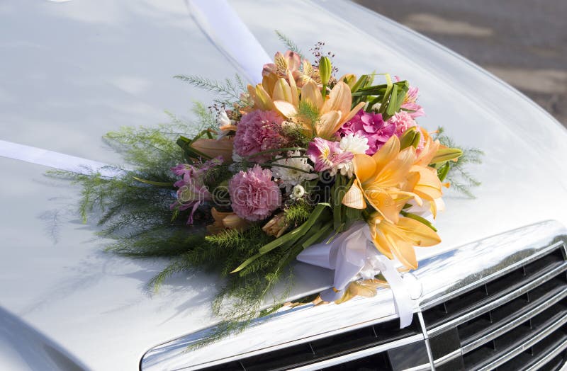 Wedding bouquet on a front hood of a car