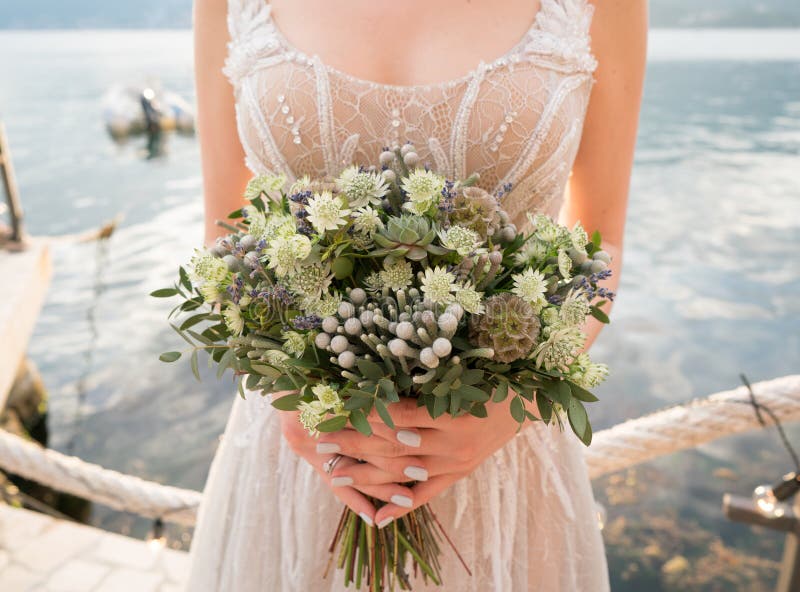 Wedding bouquet in the hands of the bride with lots of greenery