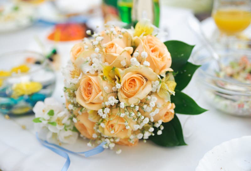 Wedding bouquet of orange roses lying on a table