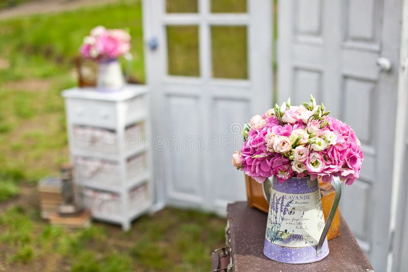 Wedding bouquet in a watering can near wedding doors decoration