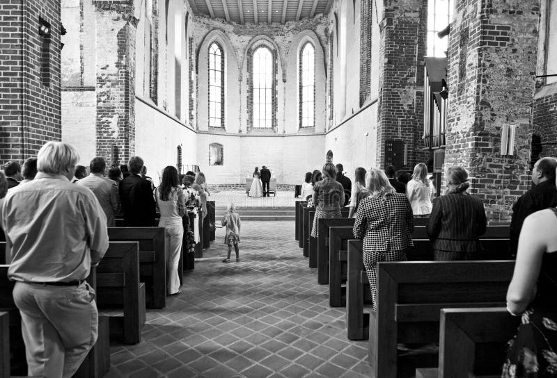 A black & white view of a wedding ceremony in a cathedral. A black & white view of a wedding ceremony in a cathedral.