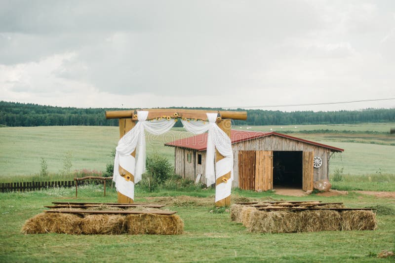 Wedding ceremony outside on a green lawn in a rustic style. Decor with arches of fresh flowers for the ceremony. Stable rustic style stock images, royalty-free photos and pictures