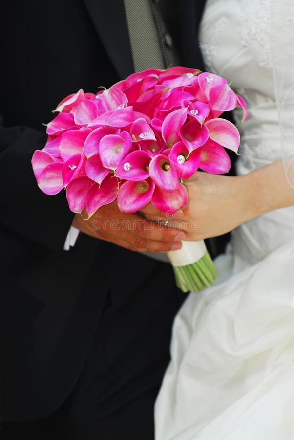 Bride and groom holding hands with wedding bouquet. Bride and groom holding hands with wedding bouquet.