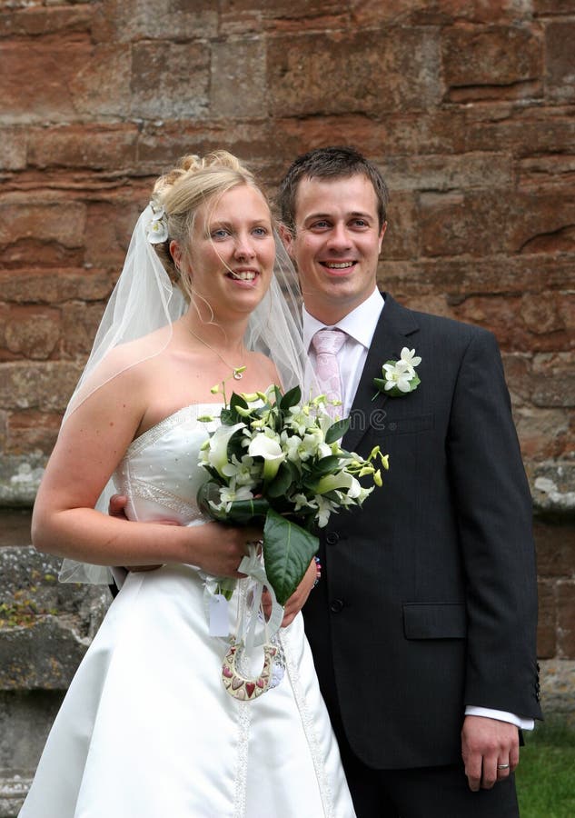 Smiling bride & groom outside church. Smiling bride & groom outside church