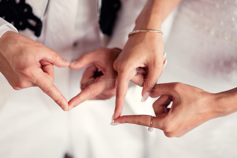 Wedding couple hands and heartshaped fingers