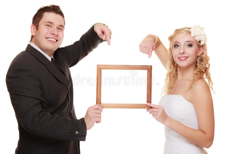 Wedding day. happy young couple pointing empty frame for photo. Isolated on white. Wedding day. happy young couple pointing empty frame for photo. Isolated on white