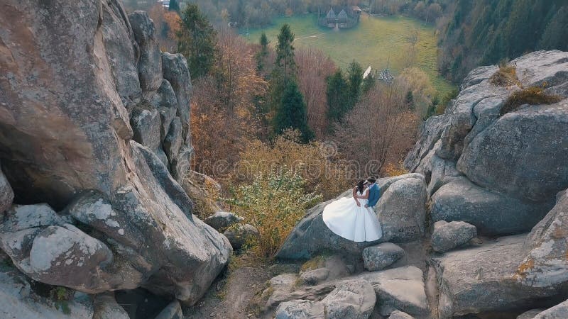 Newlyweds stand on a high slope of the mountain. Groom and bride. Arial view royalty free stock photos Newlyweds stand on a high slope of the mountain. Groom and bride. Arial view royalty free stock photos