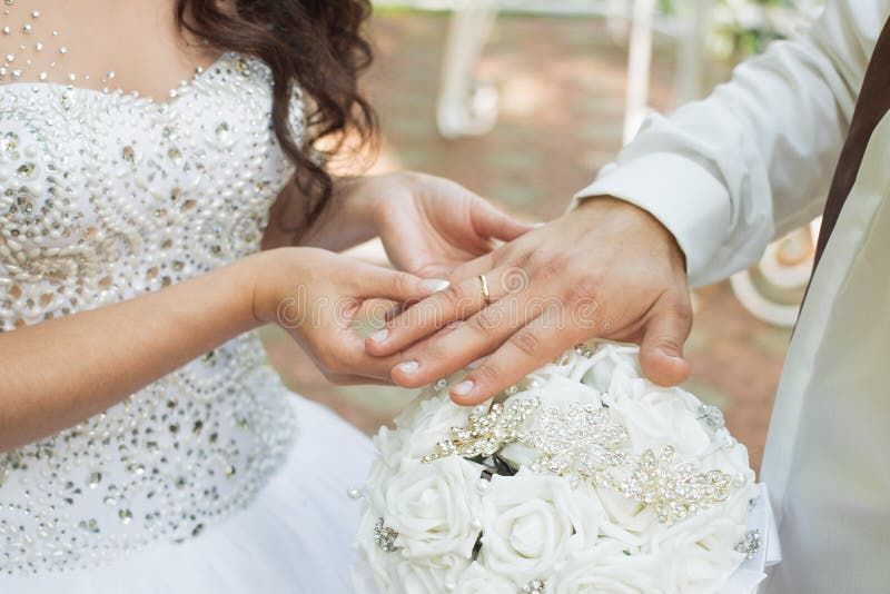 The groom places the ring on the bride& x27;s hand. Photo closeup