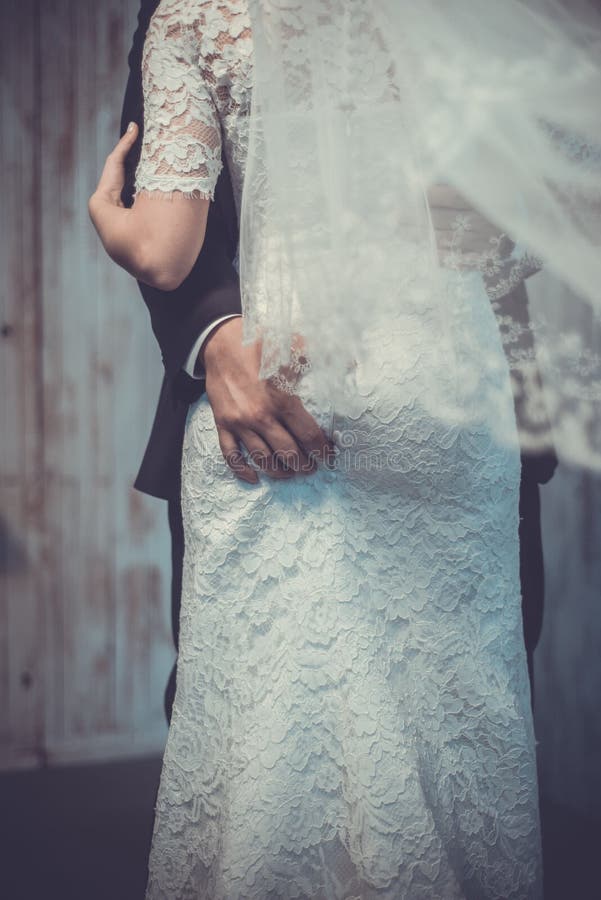 Wedding day. Groom s hand on bride s booty