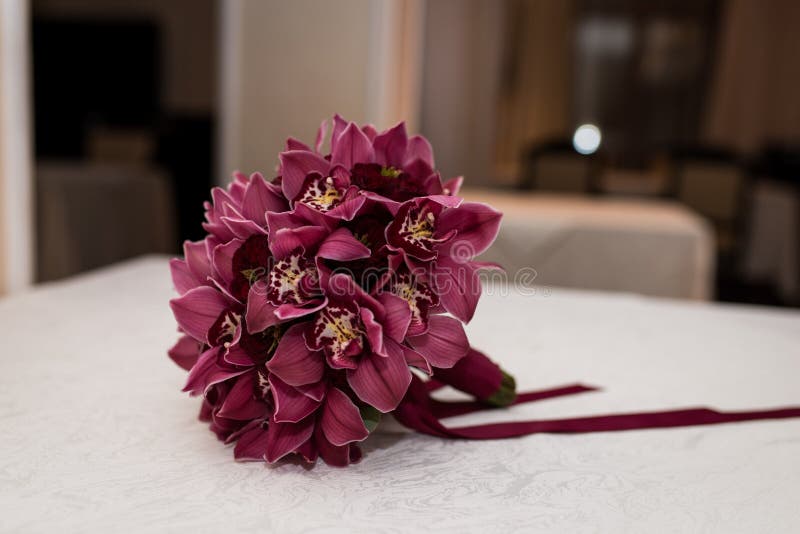 Wedding details. Bridal bouquet of red orchids with red ribbon