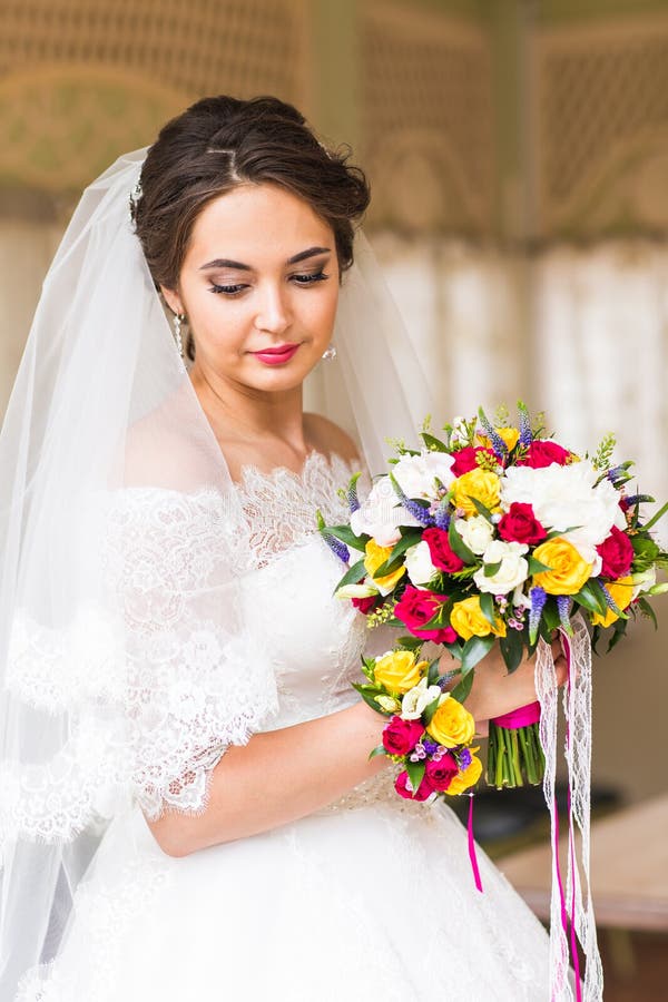 Wedding flowers ,Woman holding colorful bouquet with her hands on wedding day