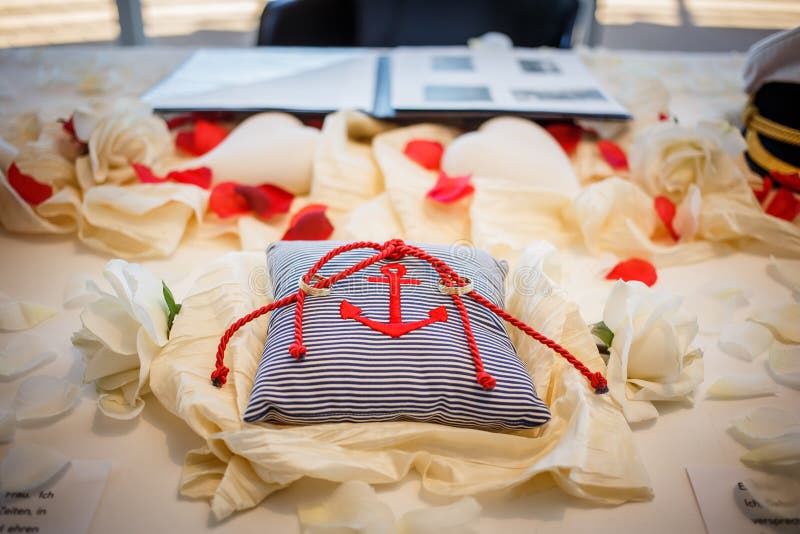 Wedding rings together with red rope on striped pillow with anchor on it. Marriage ceremony stock image Wedding rings together with red rope on striped pillow with anchor on it. Marriage ceremony stock image