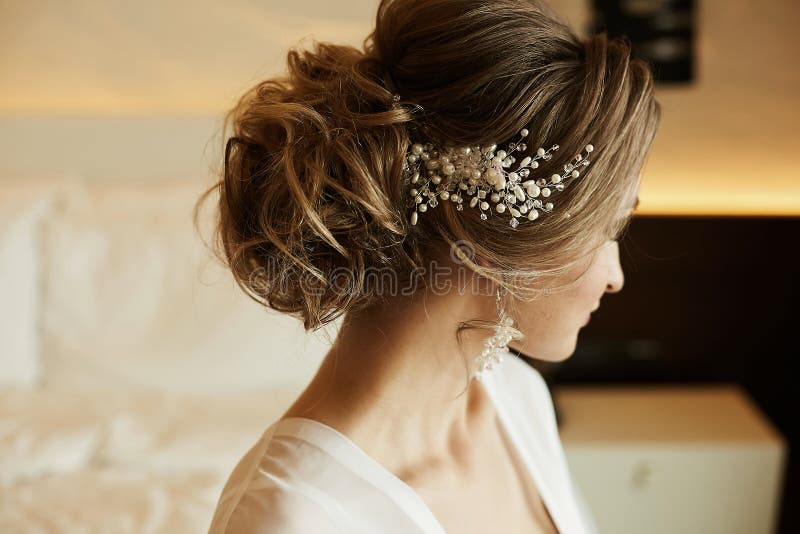 Wedding hairstyle of beautiful and fashionable brown-haired model girl in a lace dress, with earrings and jewelry in her royalty free stock photos Wedding hairstyle of beautiful and fashionable brown-haired model girl in a lace dress, with earrings and jewelry in her royalty free stock photos