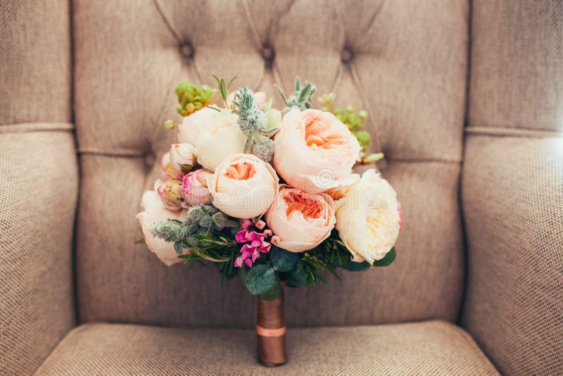 Wedding peony bouquet on a elegant armchair