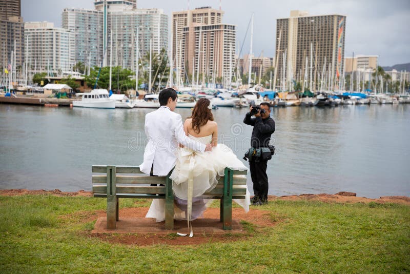 Wedding Photographer Magic Island Lagoon. ALA MOANA, HAWAII - FEBRUARY 25, 2018: Wedding photographer shooting photos of a Japanese bride and groom on a park royalty free stock photography Wedding Photographer Magic Island Lagoon. ALA MOANA, HAWAII - FEBRUARY 25, 2018: Wedding photographer shooting photos of a Japanese bride and groom on a park royalty free stock photography