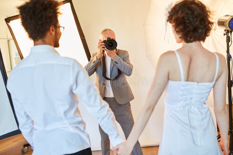 Wedding photographer takes pictures of the bride and groom. Wedding photographer takes photos of the bride and groom on the wedding day in the photo studio royalty free stock photography Wedding photographer takes pictures of the bride and groom. Wedding photographer takes photos of the bride and groom on the wedding day in the photo studio royalty free stock photography