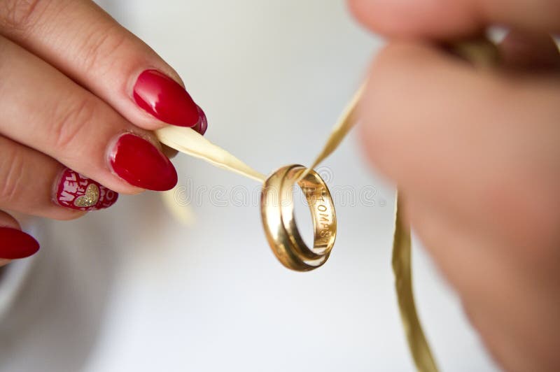 Newlyweds hold wedding rings on a string