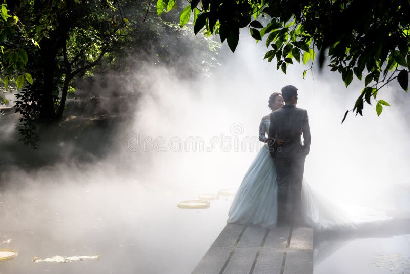 Dos joven hombres ellos eran boda fotografías sobre el puente en niebla 