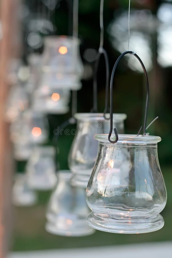 A wedding reception decorated with candles hung in the trees