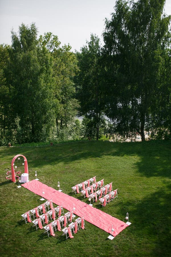 Wedding registration beautiful in nature. White chairs for visiting registration. Pink tent with white flowers for the. Camera, scenery.